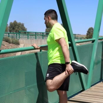 Homme faisant un étirement du quadriceps en extérieur après le sport