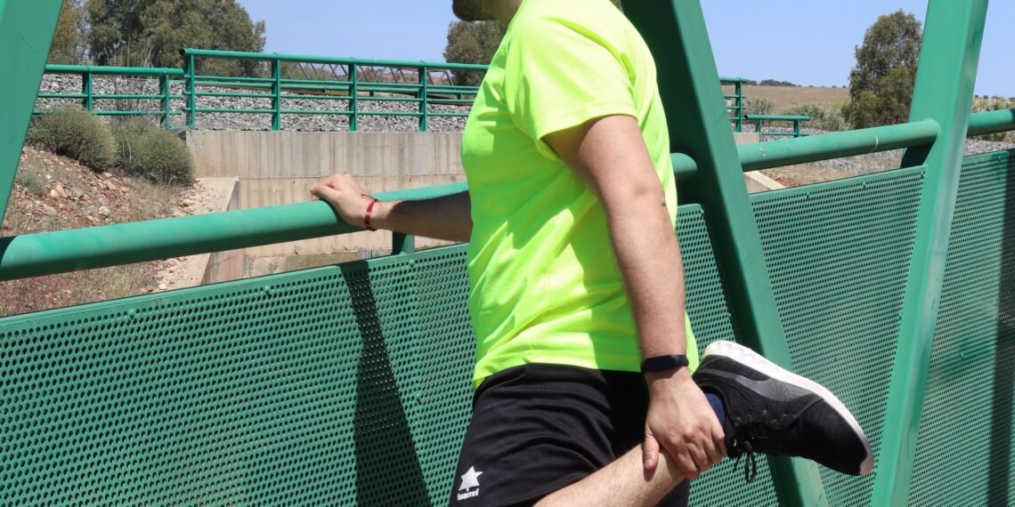 Homme faisant un étirement du quadriceps en extérieur après le sport