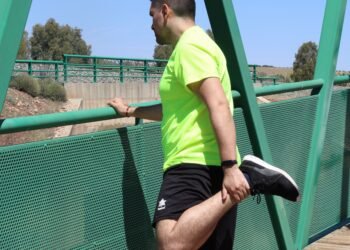 Homme faisant un étirement du quadriceps en extérieur après le sport