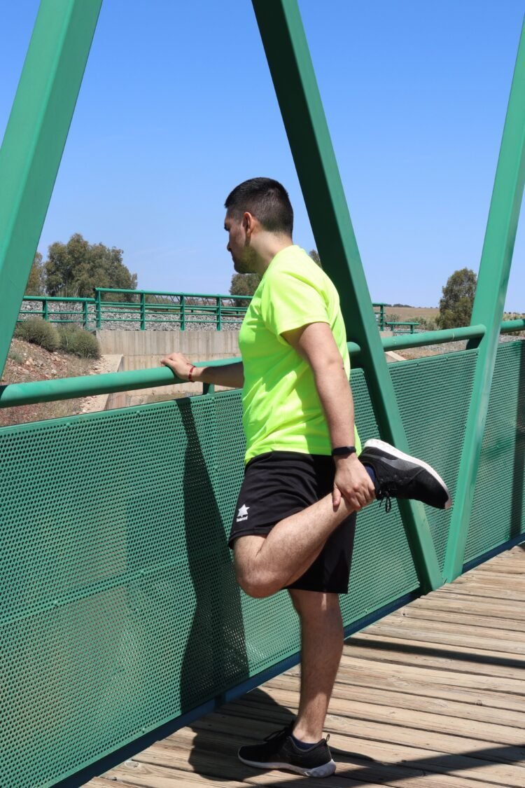 Homme faisant un étirement du quadriceps en extérieur après le sport